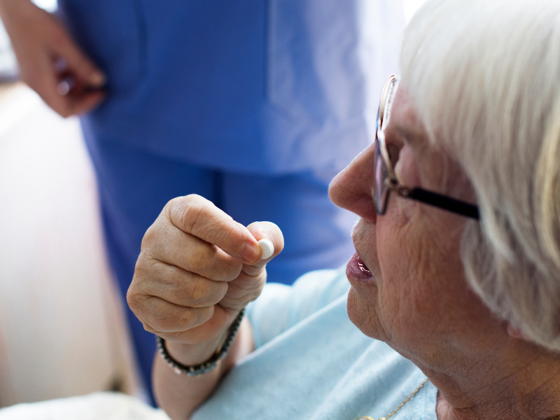 Infirmière distribuant des médicaments depuis un pilulier nominatif en EHPAD